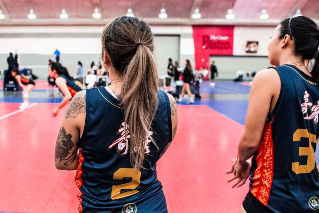 Two women watching a volleyball game